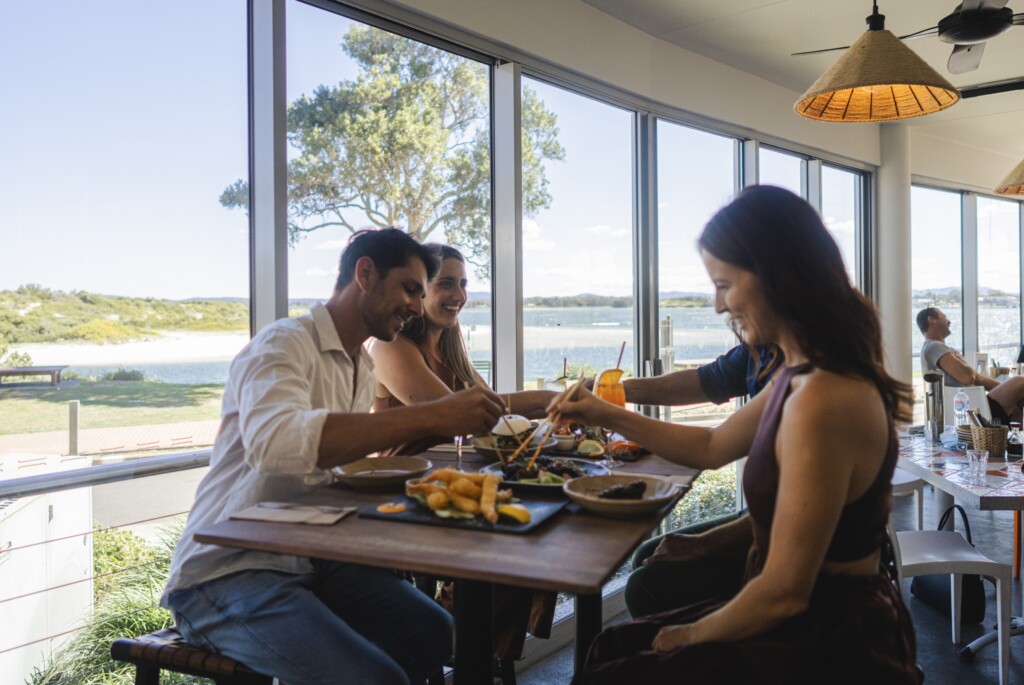 Friends enjoying food and drink at Spice Monkey restaurant, Forster.